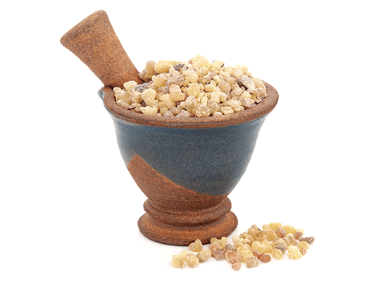 Frankincense displayed in a beautiful stonework mortar and pestle, on a white background.